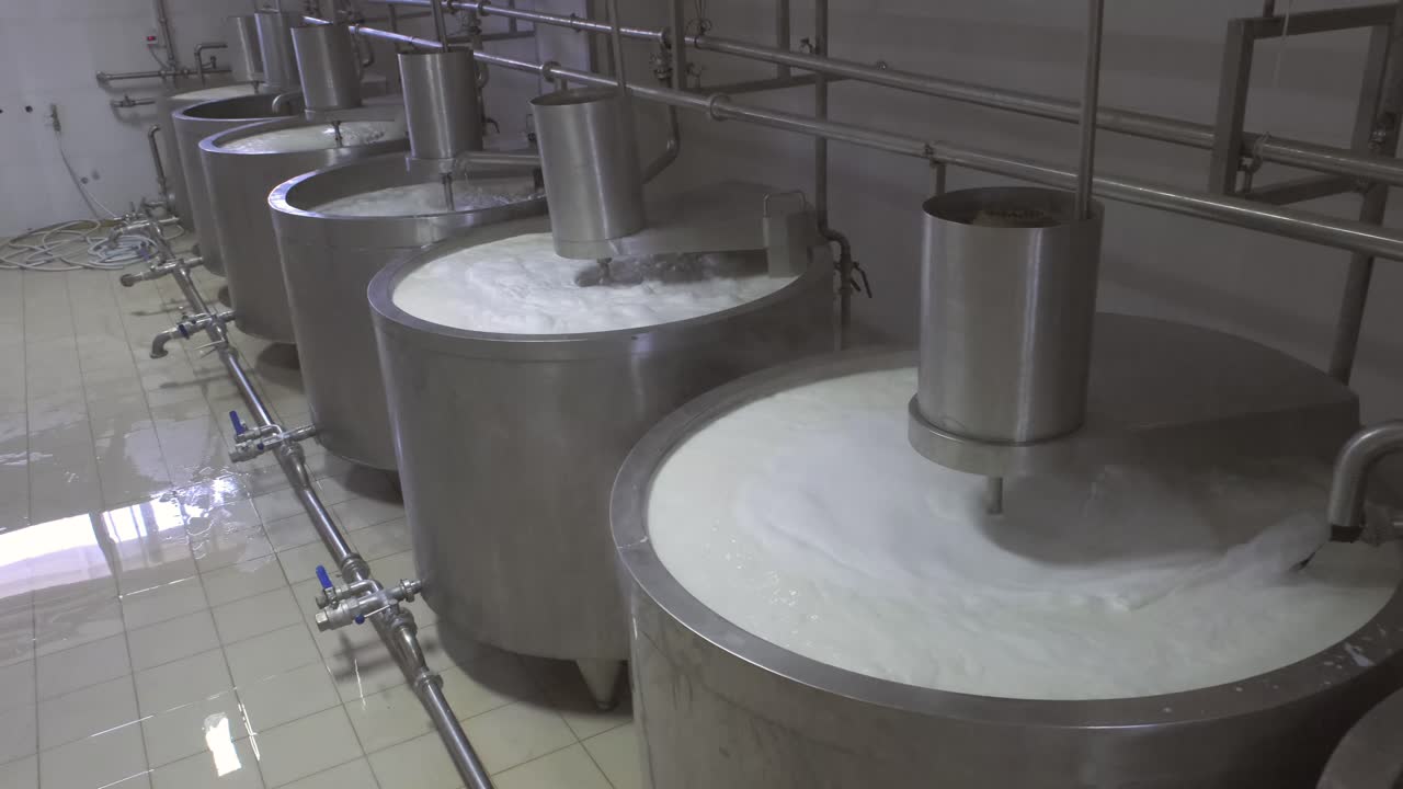 Milk pouring into the boiler at the cheese production plant