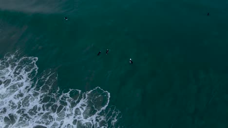 Luftaufnahme-Von-Surfern,-Die-Im-Wasser-Sitzen