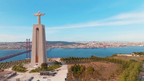 view of christ statue and suspended bridge over blue seascape, lisbon, portugal