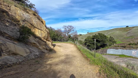 POV-first-person-walk-through-desolated-trekking-path-with-it's-own-shadow-skyline-at-daylight