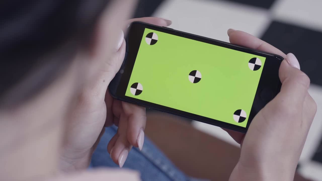 초록색 화면 을 가진 스마트폰 을 사용하는 여자