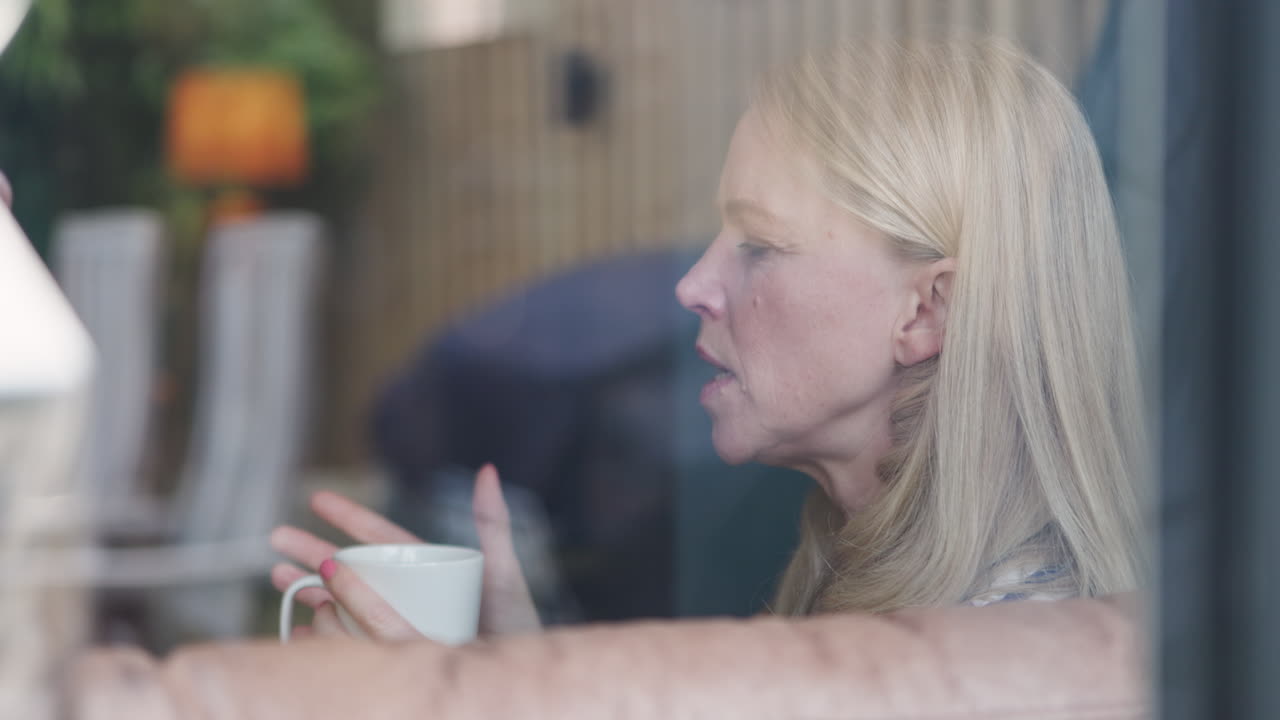 Woman with coffee cup behind window