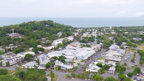 aerial footage captures lush greenery and coastal townscape in port douglas, queensland. overcast skies create a serene, natural ambiance