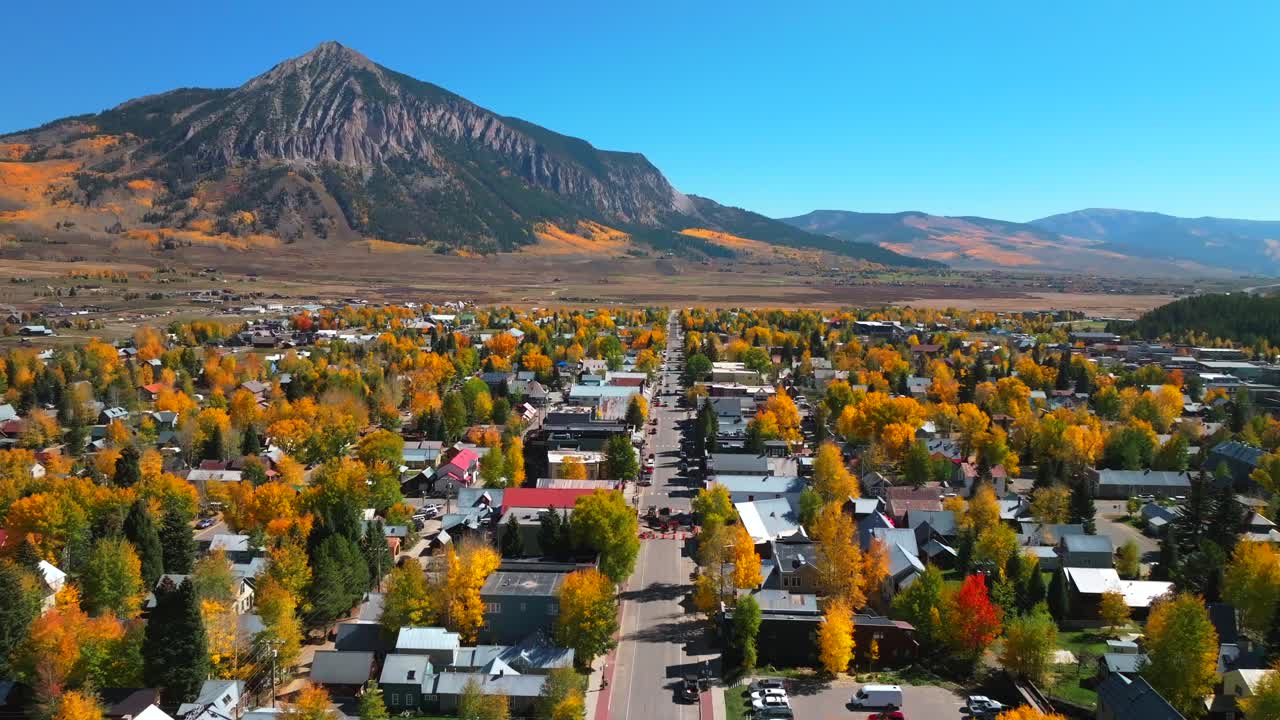 Main street Mount Crested Butte mountain town ski resort Kebler Ohio Pass aerial drone Colorado morning vibrant Aspen Trees fall autumn peak colors Gunnison National forest sunny blue sky upwards