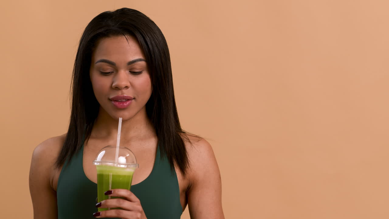 una mujer disfrutando de un batido verde saludable.