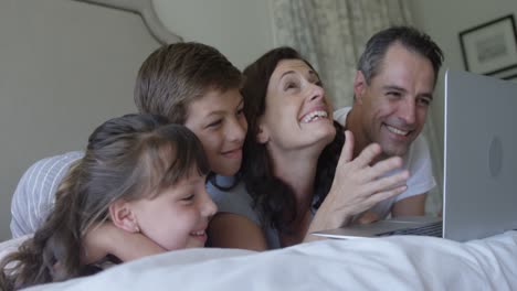 Glückliche-Familie-Mit-Laptop-Auf-Dem-Bett-Im-Schlafzimmer