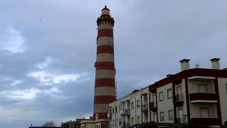 Static-tilt-up-shot-of-Faro-da-Barra-behind-some-houses-in-Praia-da-Costa-Nova