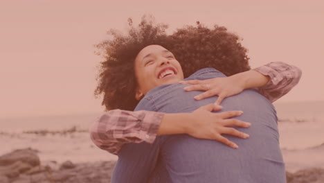 una feliz pareja afroamericana abrazándose en la playa.