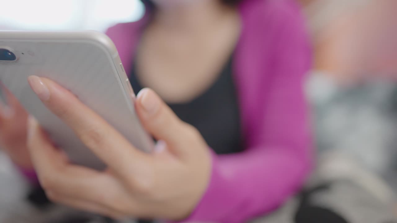 una mujer en primer plano sentada en un sofá sosteniendo un teléfono inteligente para comprar en línea en casa