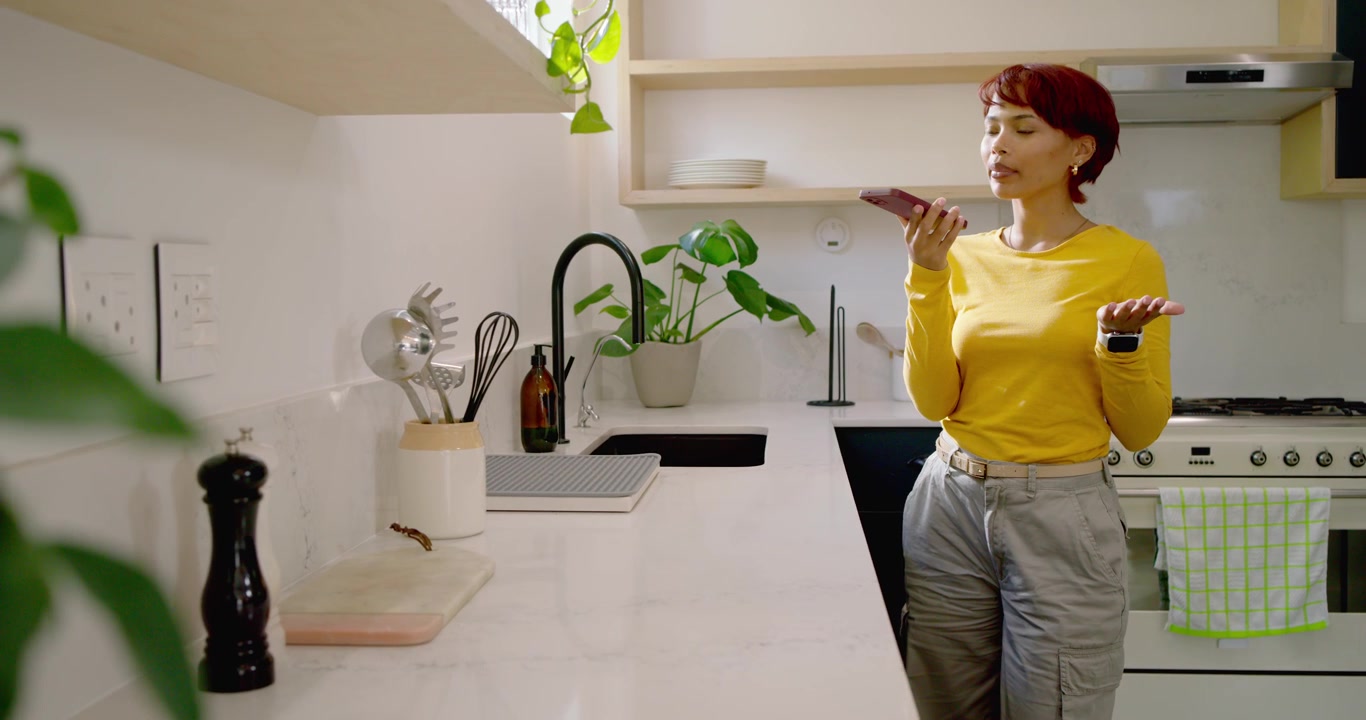 Donna afroamericana che risponde a una chiamata, parlando al telefono a un bancone bianco con un top giallo, spazio per il testo