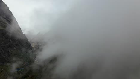 Aerial-drone-shot-going-through-the-clouds-into-the-Annapurna-mountains,-Nepal