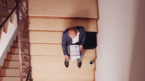 top view of entrepreneur reading financial statistics from clipboard