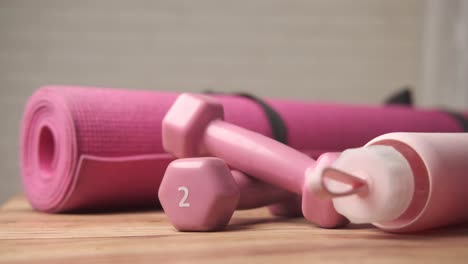 pink yoga mat, dumbbells, and water bottle