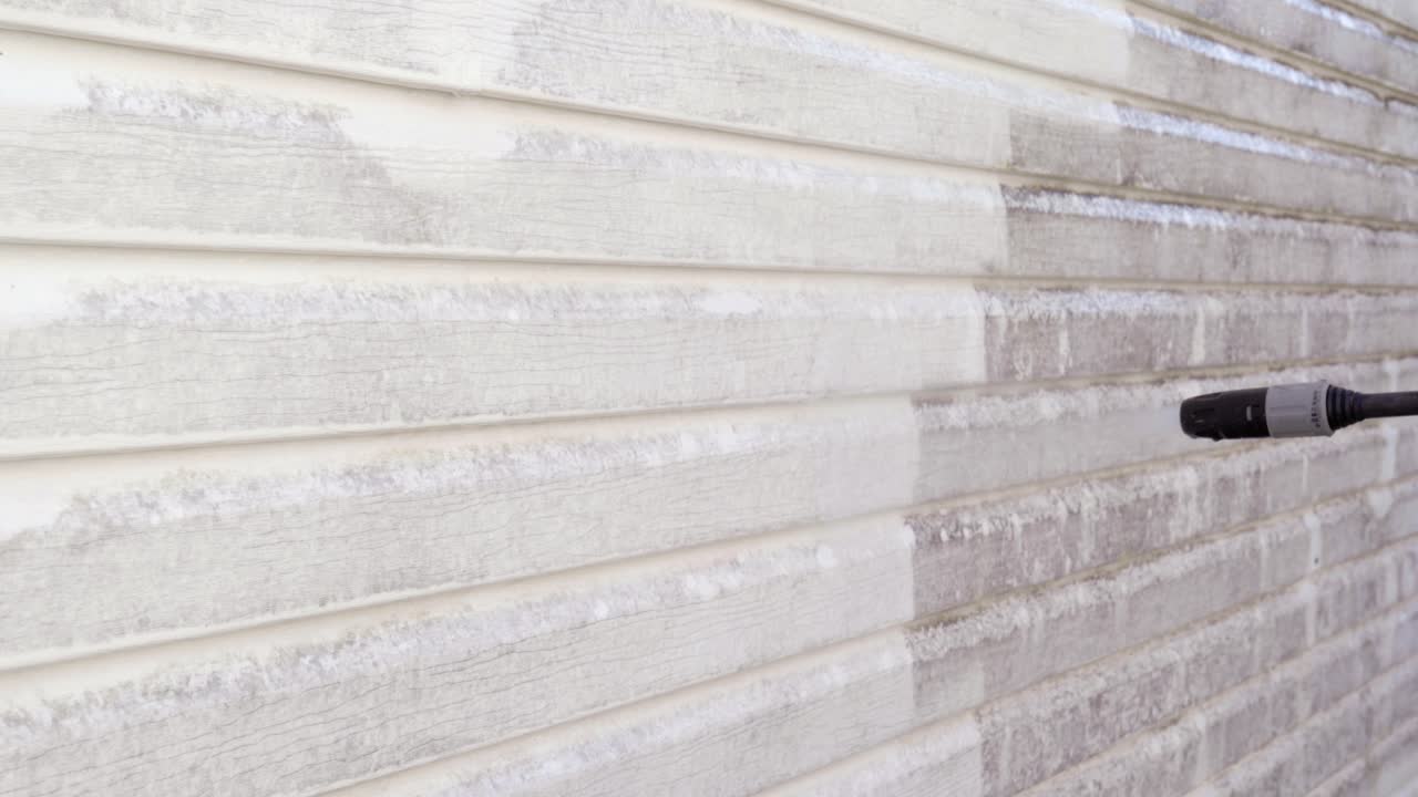 Power washing dirty vinyl siding. Close-up