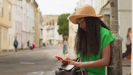 Turista-De-Vacaciones-En-Oxford,-Reino-Unido,-Explorando-La-Ciudad-Caminando-Por-Holywell-Street-Usando-El-Teléfono-Móvil-Para-Obtener-Direcciones-E-Información