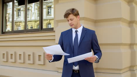 closeup man reading documents at street. male professional looking away outdoors