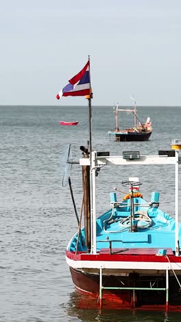 barco anclado con bandera tailandesa en las aguas de chonburi