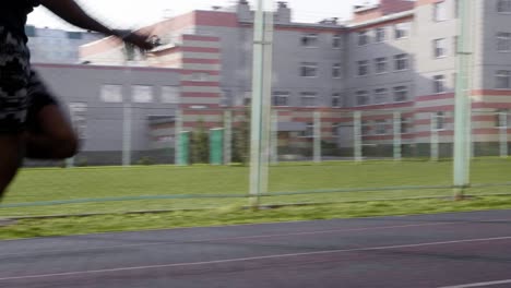 man running on a track in an urban setting