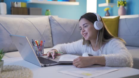 una joven alegre estudiando mientras escucha música.