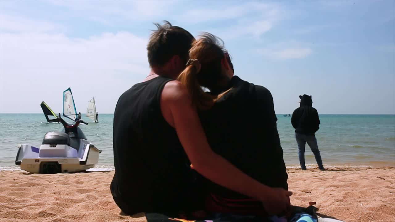 바가에서 휴식을 취하고 물 스포츠를 보는 커플