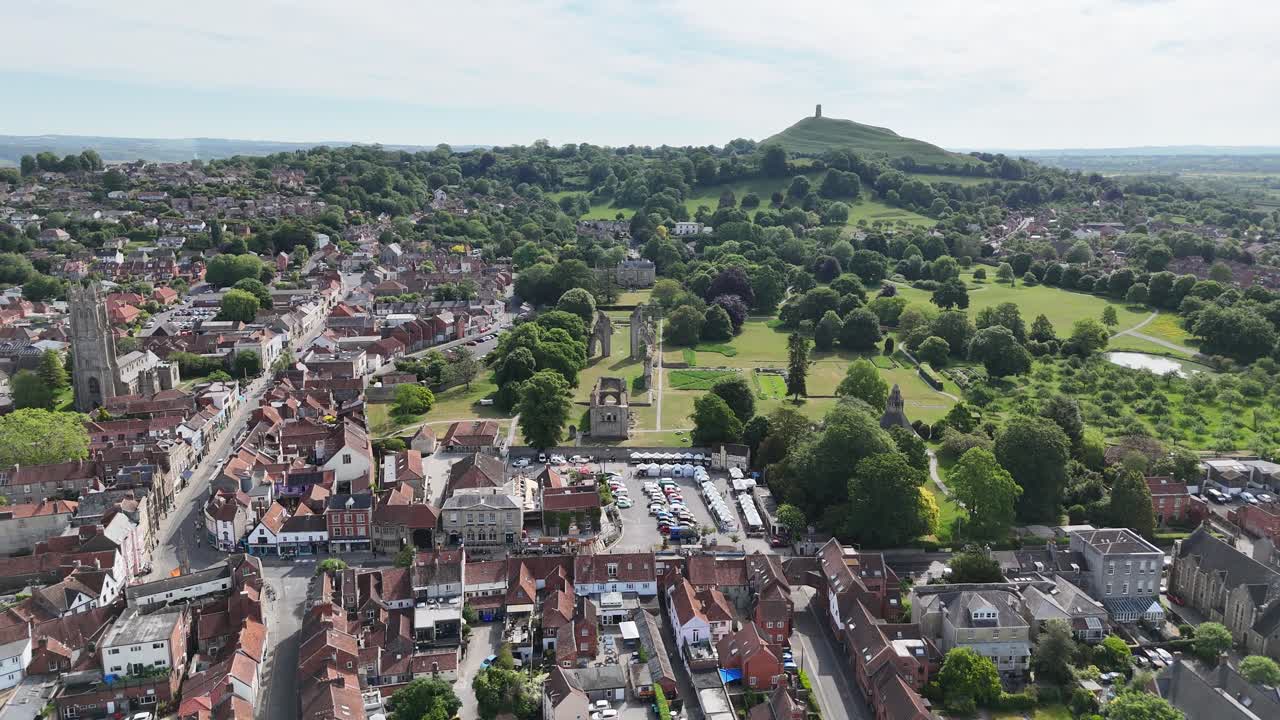 Glastonbury town Somerset UK high angle Panning drone aerial Glastonbury Tor in background