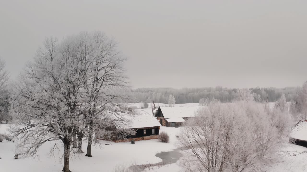 Ascending drone shot overlooking family house in the suburbs with forest in the background. Winter scenery in the countryside with wooden home.