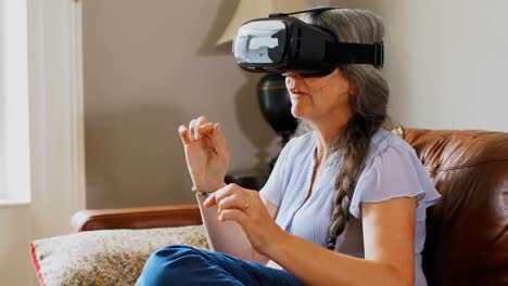 vista lateral de una anciana caucásica usando auriculares de realidad virtual en un cómodo hogar 4k