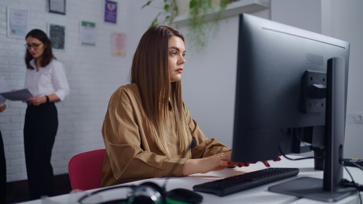 Frau arbeitet am Computer in einer Büroumgebung