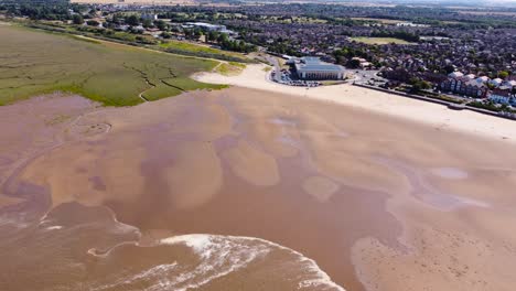 Absteigende-Luftaufnahme-über-Den-Sandstrand-Von-Grimsby-Cleethorpes-In-Richtung-Freizeitzentrum,-Solarpanel-Dachgrundstück