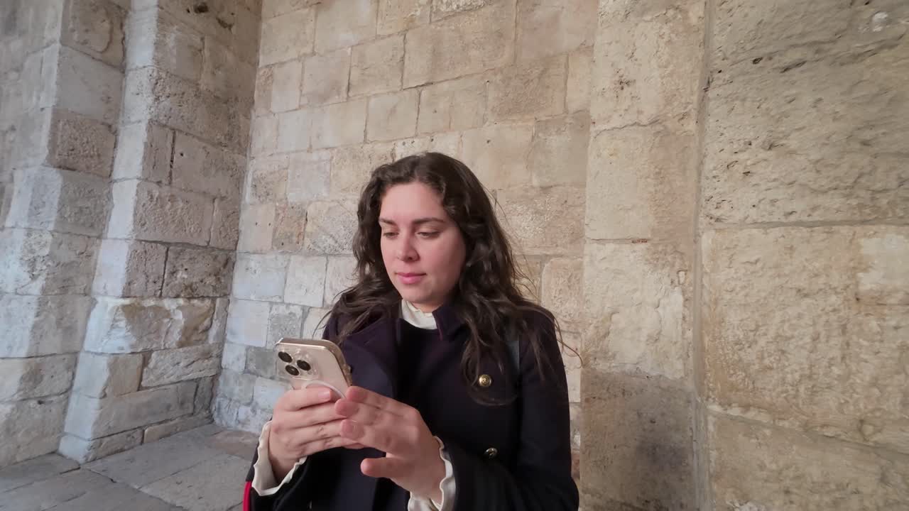 Un viaggiatore usa un dispositivo mobile in un luogo storico della Città Vecchia di Gerusalemme. Rallentatore.