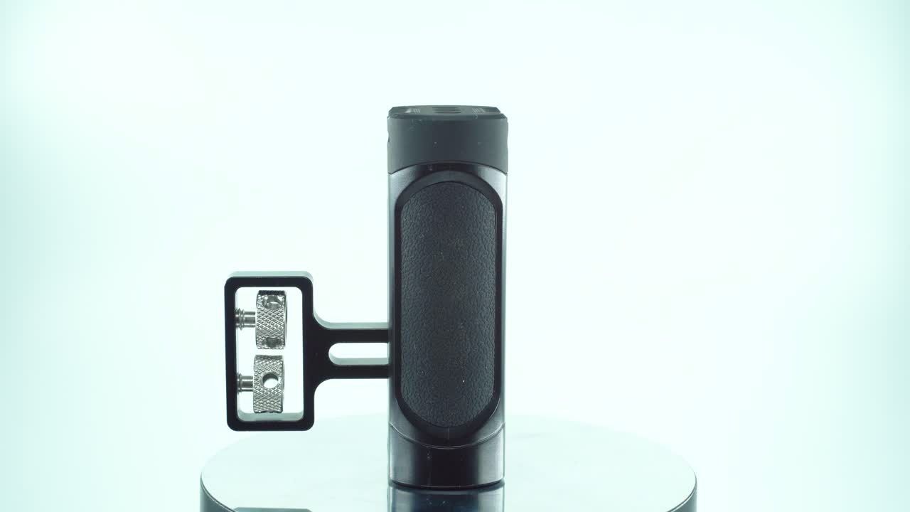 un primer plano de un controlador de cámara de metal negro, equipo de producción de video, en un soporte giratorio de 360, iluminación de estudio, cámara lenta, 4k