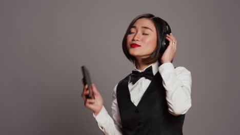 front desk staff playing music on headphones using phone app