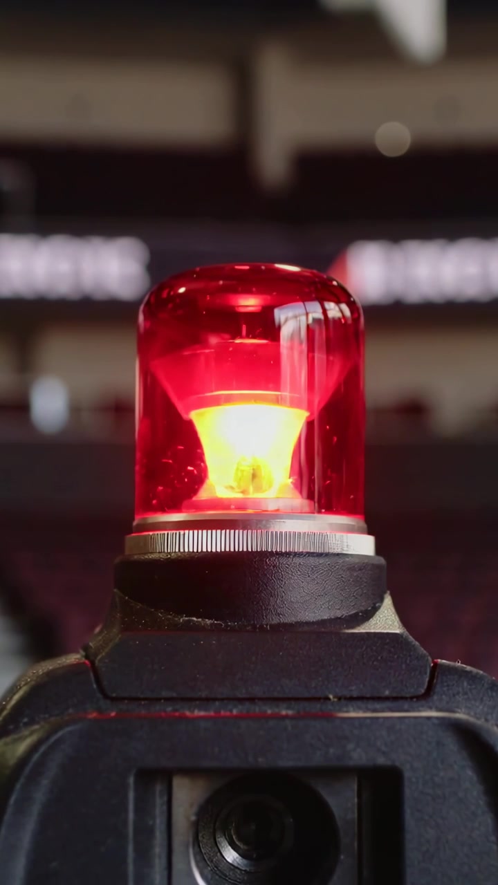 Vídeo vertical: Farol vermelho giratório pulsando para alertar em uma arena, lâmpada se movendo, anel, fita de LED.