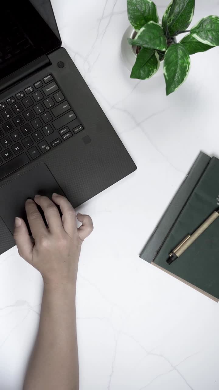 Overhead View of Hand Using Laptop Trackpad on Desk