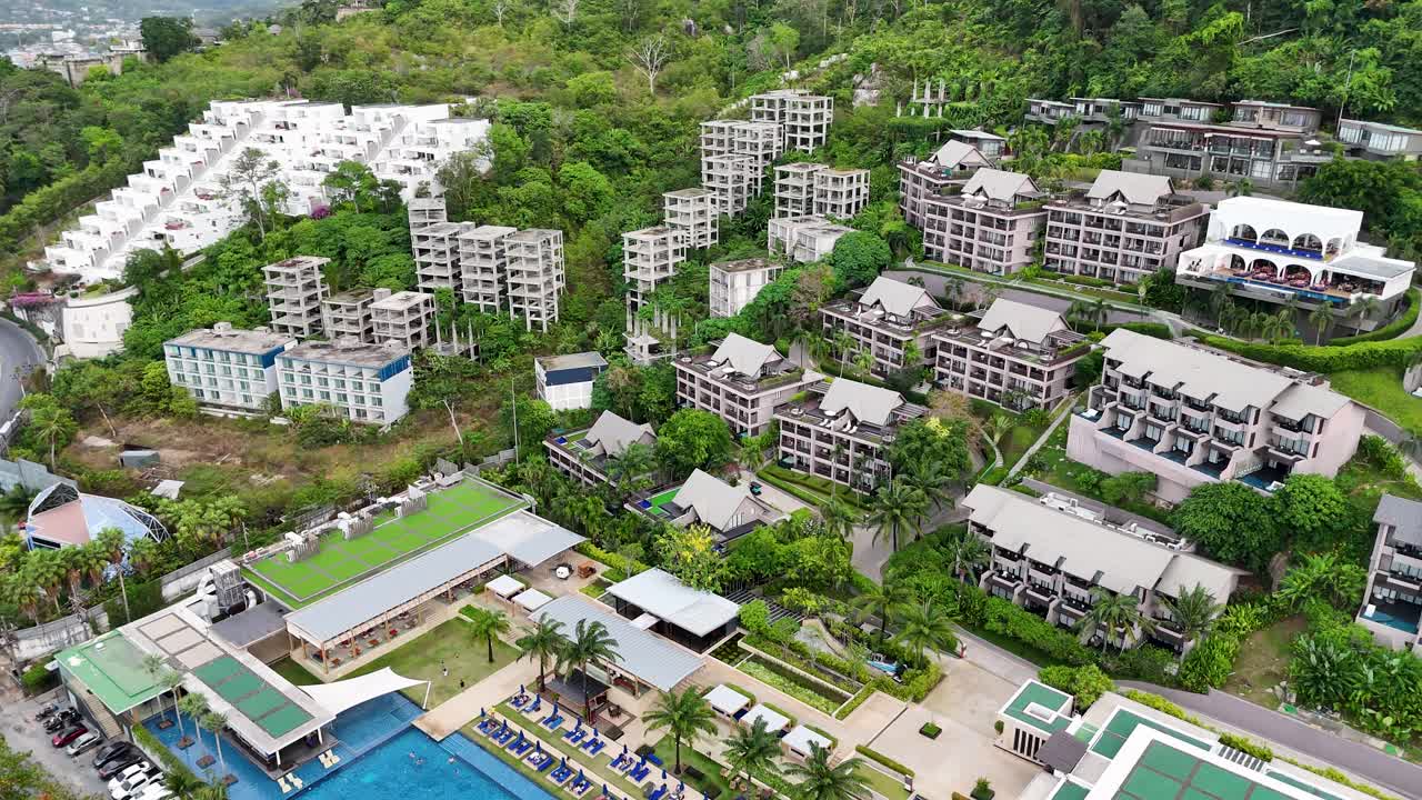 Drone footage captures a lush resort in Phuket, Thailand, showcasing pools and greenery from above with smooth camera movement