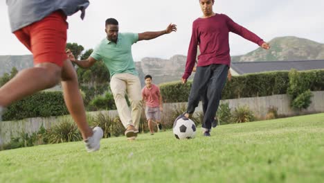 Fröhliche,-Vielfältige-Männliche-Freunde,-Die-An-Sonnigen-Tagen-Im-Garten-Fußball-Spielen