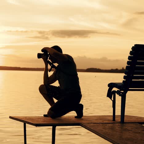 silhouette photographer on the golden beach during sunrise / sunset. work on vacation