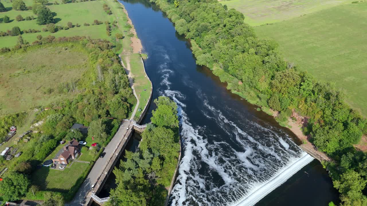 Aerial drone sunset over Gunthorpe Weir and River Trent Nottinghamshire with navigation canal and rural green English countryside landscape summer evening