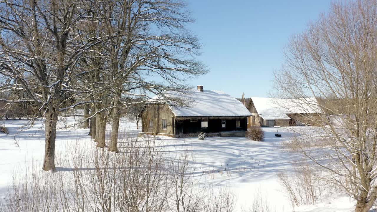 Aerial view of a guesthouse in the countryside during winter with lots of snow. Winter wonderland in historic suburb area on a bright and sunny winter day.