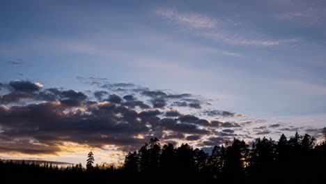 Sunset-timelapse-of-clouds-moving-in-over-forest,-Birkeland,-Norway