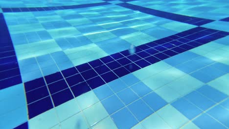 pov of person diving i9nto the blue pool, hands extended forward. ideal for themes related to swimming, water sports, fitness, leisure, pool activities, and underwater perspectives.