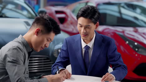 couple with attractive auto dealer in a suit presenting new car model to his client