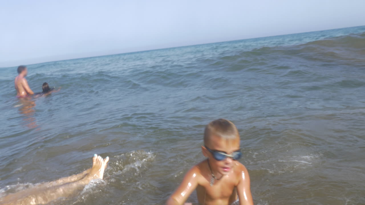 공 을 들고 바다 에 목욕 하는 놀이 하는 아이