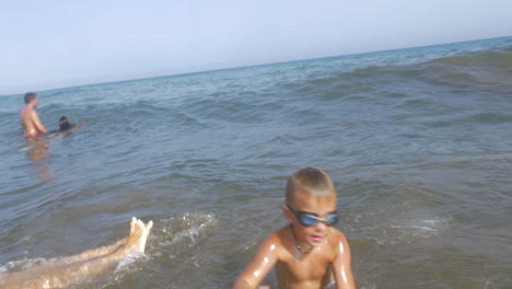 Niño-Juguetón-Bañándose-En-El-Mar-Con-Pelota