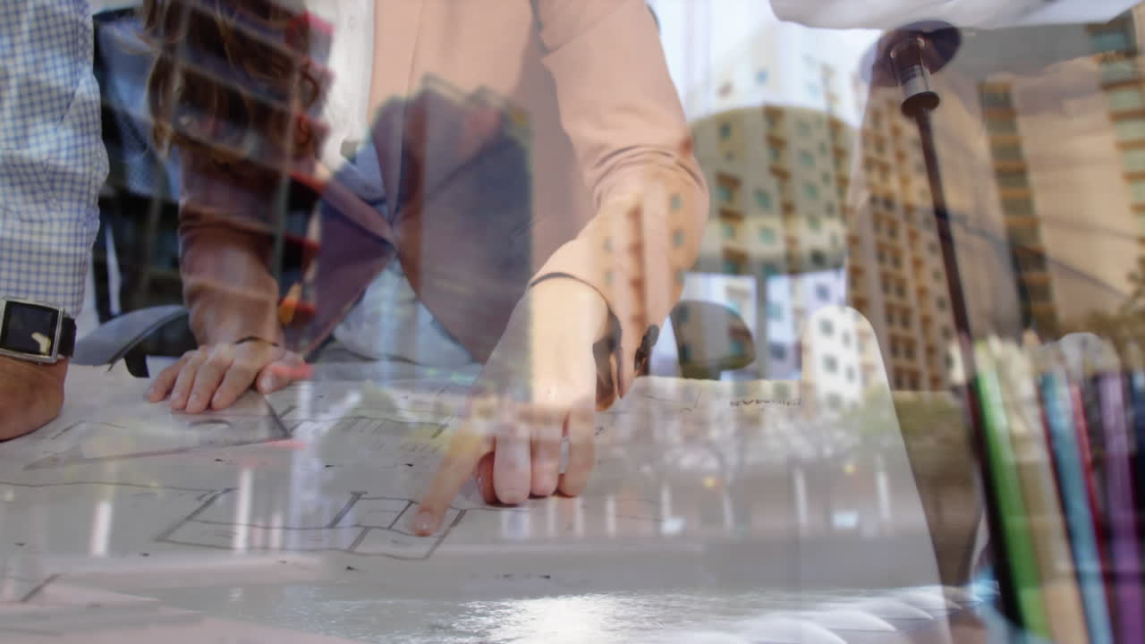 사무실 에서 바닥 계획 과 건물 의 배경 에 대해 논의 하는 사람 들