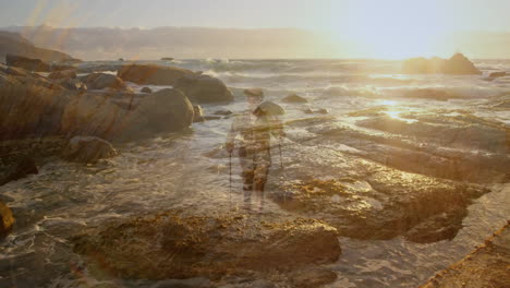 male hiker trekking on rocky shore at sunset, with animated map icons showcasing digital technology