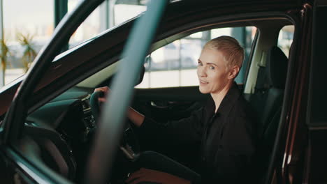 woman test driving a car in a showroom