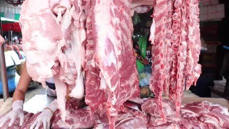 butcher cutting and arranging meat in shop