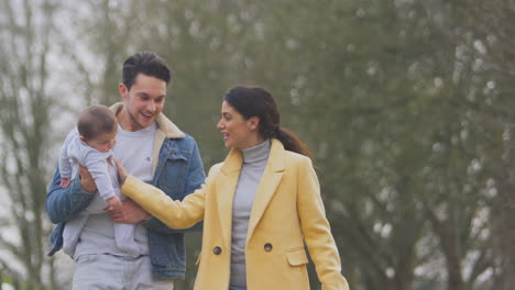 Familia-Transgénero-Con-Bebé-Y-Perro-Mascota-Disfrutando-De-Un-Paseo-En-El-Campo-De-Otoño-O-Invierno