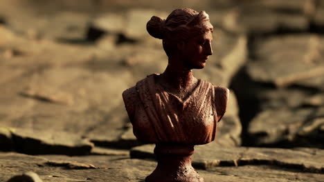 ancient statue of woman on rocky stones